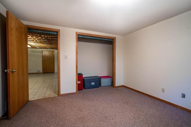 unfurnished bedroom featuring baseboards, carpet floors, and a closet