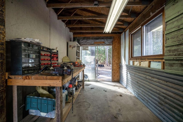 miscellaneous room featuring a workshop area and unfinished concrete flooring