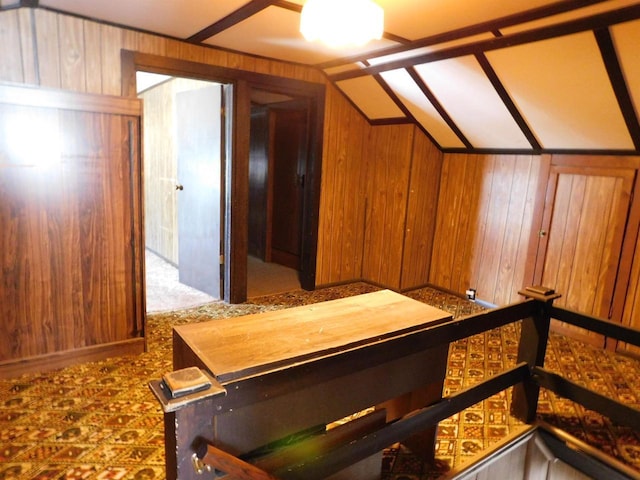 bonus room featuring lofted ceiling and wood walls