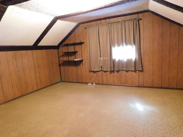 additional living space with lofted ceiling and wooden walls