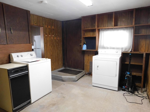 laundry room with washer and clothes dryer, laundry area, and wood walls