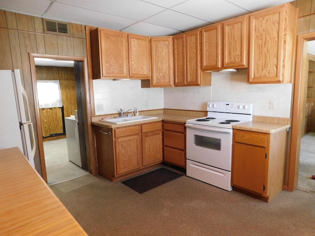 kitchen featuring visible vents, a drop ceiling, light countertops, white appliances, and a sink