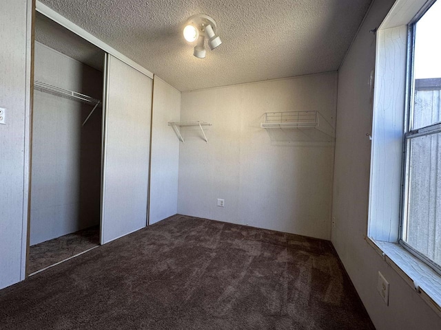 unfurnished bedroom featuring carpet flooring, a closet, and a textured ceiling