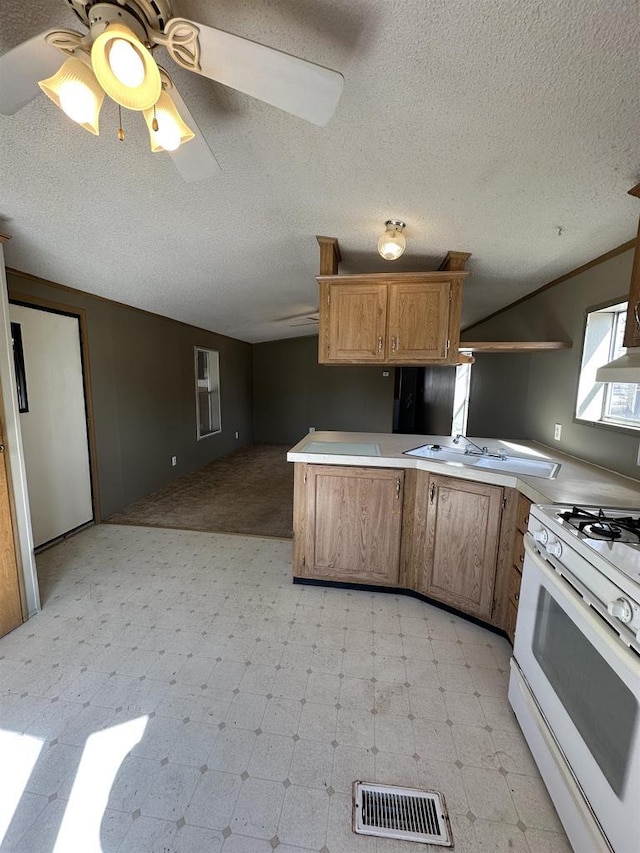 kitchen with visible vents, light floors, light countertops, and gas range gas stove