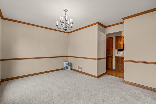 unfurnished room featuring visible vents, crown molding, baseboards, light colored carpet, and a chandelier