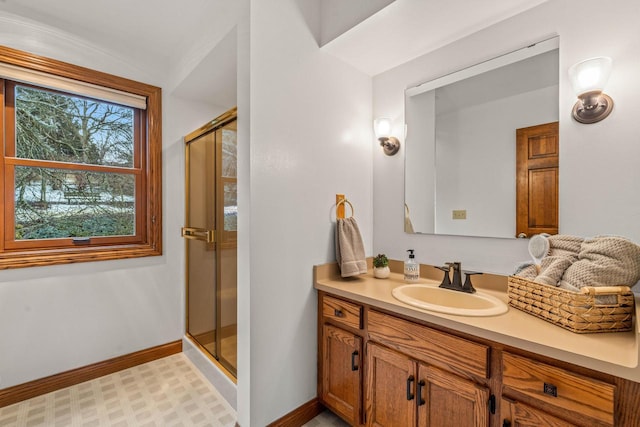 bathroom featuring vanity, baseboards, and a stall shower