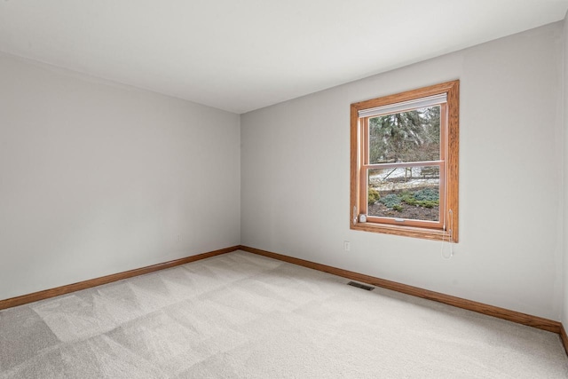 empty room with visible vents, light colored carpet, and baseboards