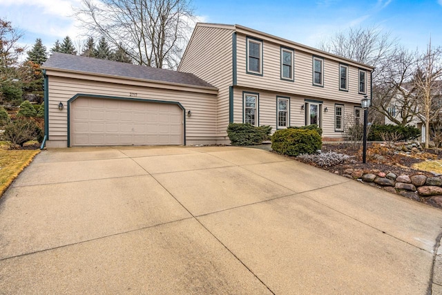 colonial home with concrete driveway and an attached garage