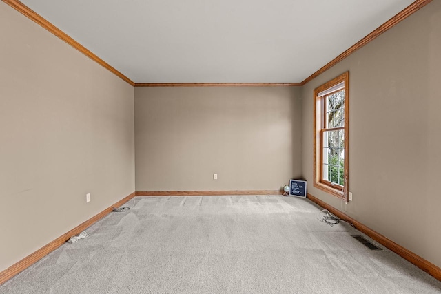 empty room featuring crown molding, baseboards, visible vents, and light carpet