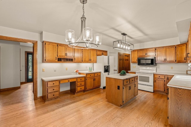 kitchen featuring a sink, white appliances, a kitchen island, and light wood-style flooring