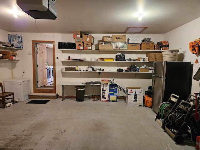 garage featuring washer / clothes dryer, a garage door opener, and freestanding refrigerator