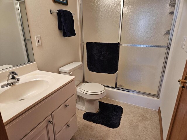 bathroom with vanity, a shower stall, and toilet