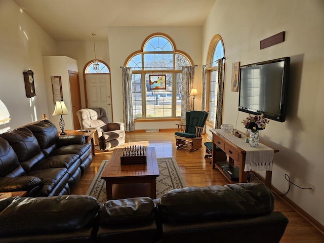 living room with visible vents, baseboards, and wood finished floors