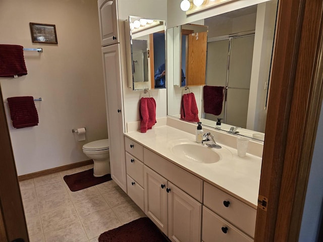 bathroom featuring toilet, a shower with door, tile patterned flooring, baseboards, and vanity