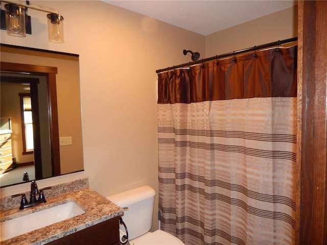 full bath featuring curtained shower, toilet, and vanity