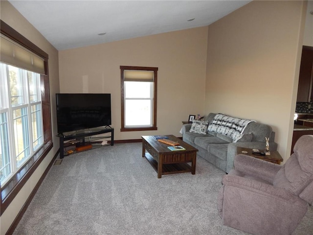 living area featuring baseboards, carpet flooring, and vaulted ceiling