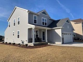 view of front of house with a garage, driveway, and a front lawn