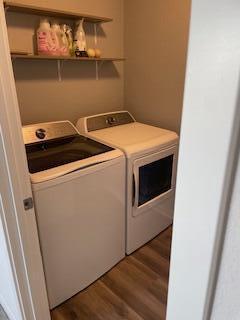 laundry area with dark wood-style floors, laundry area, and washing machine and dryer