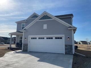 view of side of home featuring concrete driveway and a garage