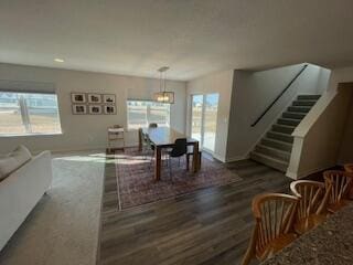 dining area with plenty of natural light, stairs, and wood finished floors