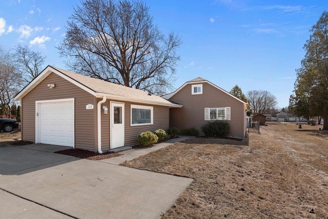 exterior space with an outbuilding, a garage, and driveway