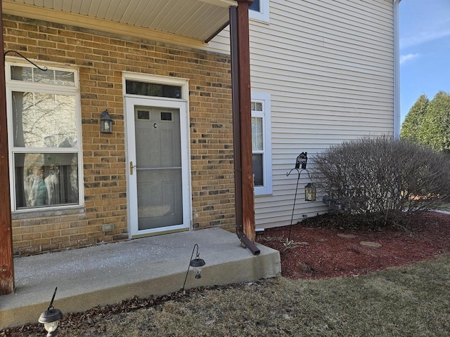 view of exterior entry with brick siding