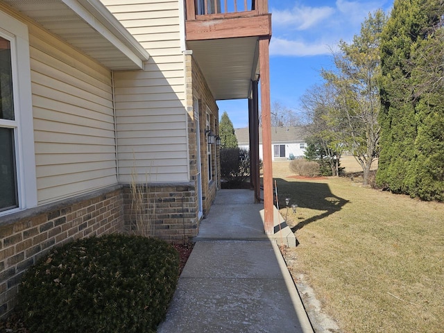 view of side of home featuring a lawn and brick siding