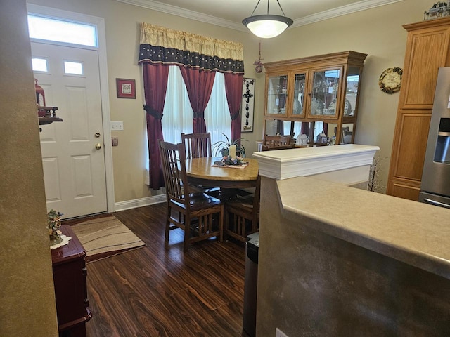 dining room featuring baseboards, dark wood finished floors, and crown molding