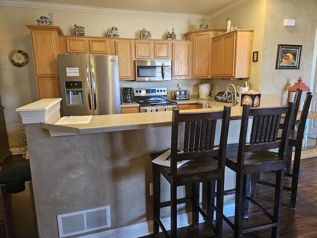 kitchen with visible vents, a peninsula, stainless steel appliances, dark wood-type flooring, and crown molding