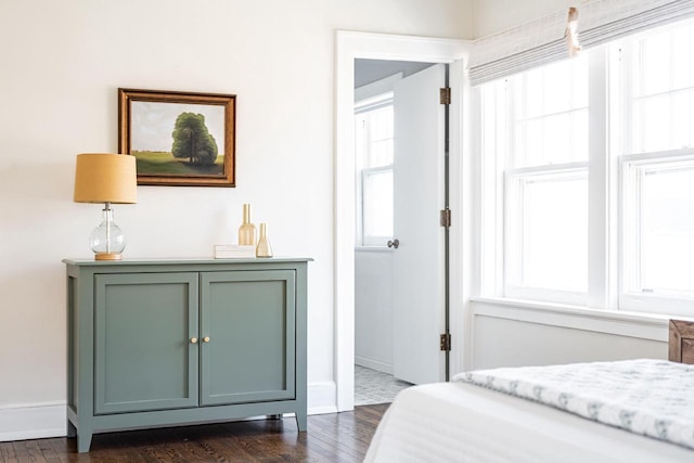 bedroom featuring multiple windows, baseboards, and dark wood-style flooring