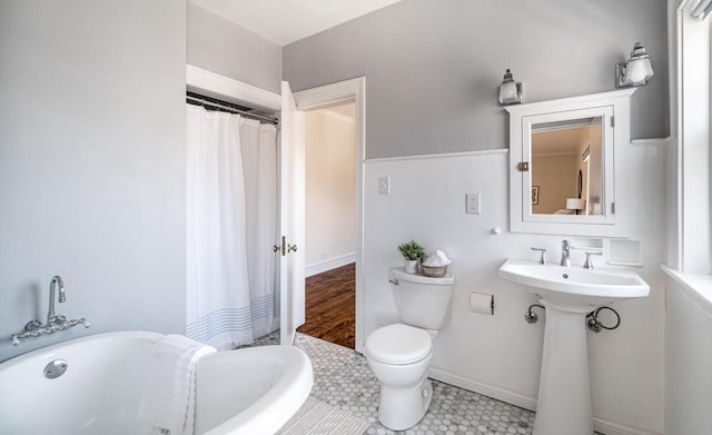 bathroom with a sink, curtained shower, tile walls, toilet, and a washtub