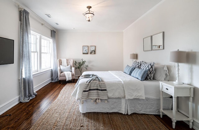 bedroom with visible vents, crown molding, baseboards, and hardwood / wood-style flooring