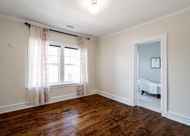 unfurnished room with dark wood finished floors, visible vents, baseboards, and ornamental molding