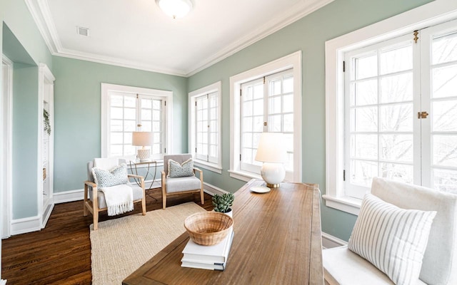 sitting room featuring crown molding, wood finished floors, baseboards, and a wealth of natural light