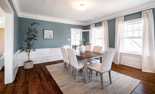 dining room with crown molding, baseboards, and wood finished floors