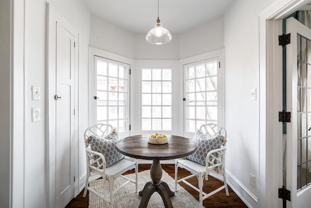 dining room with breakfast area, baseboards, and dark wood-style flooring