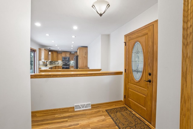 entryway with recessed lighting, visible vents, baseboards, and light wood finished floors