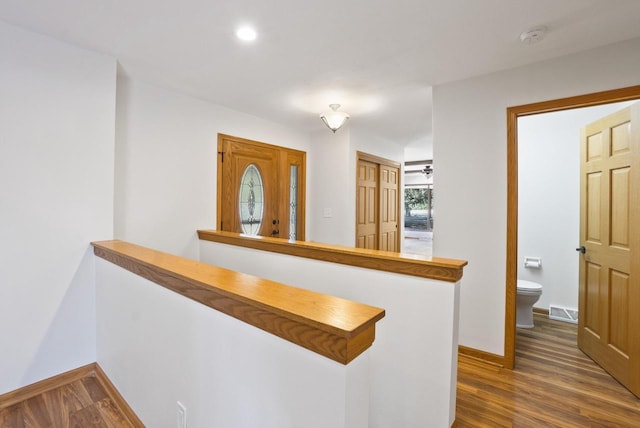 hall featuring visible vents, recessed lighting, baseboards, and dark wood-style flooring