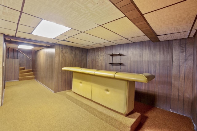 bar with a paneled ceiling, stairway, carpet floors, and wood walls