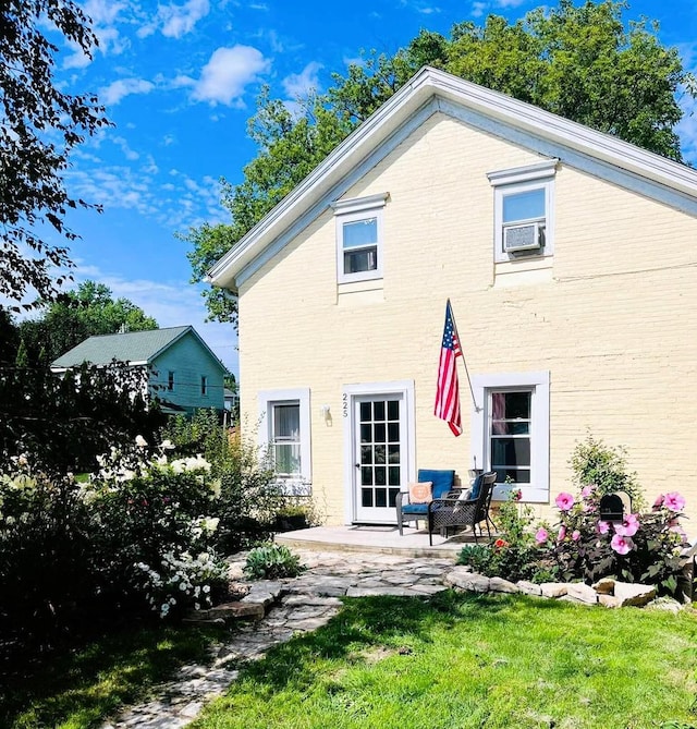 back of house featuring cooling unit, a patio area, and brick siding