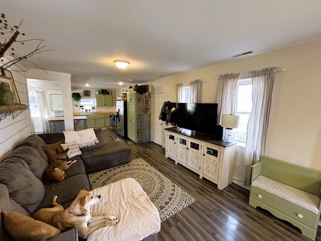 living area with dark wood-style floors and visible vents