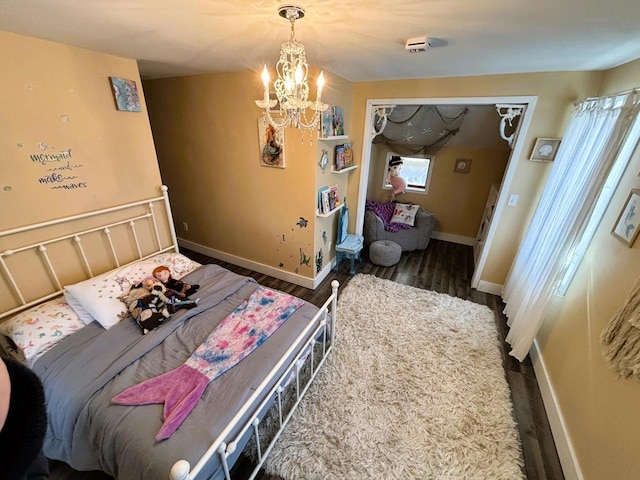 bedroom featuring baseboards, an inviting chandelier, and wood finished floors