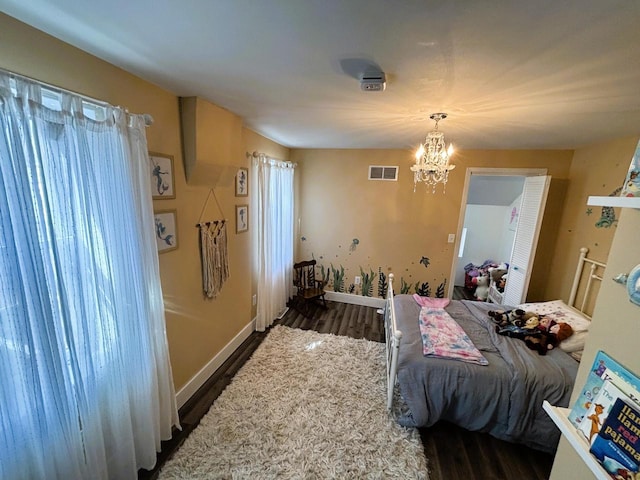 bedroom with an inviting chandelier, baseboards, visible vents, and dark wood-style flooring