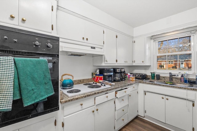 kitchen featuring a sink, black oven, under cabinet range hood, white cabinetry, and white electric stovetop