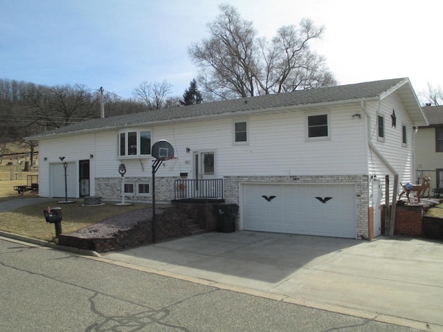 raised ranch featuring driveway and an attached garage