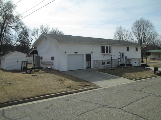 view of front of house featuring a front lawn, concrete driveway, and a garage