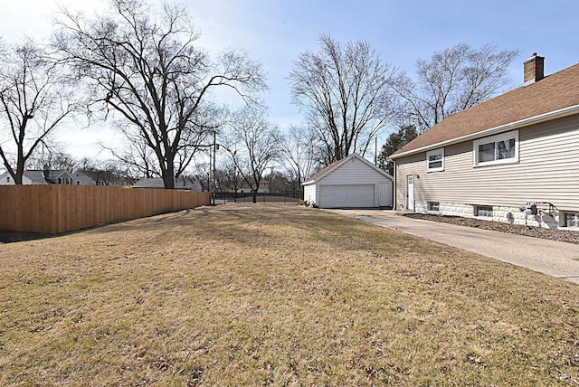 view of yard with a garage, an outbuilding, and fence