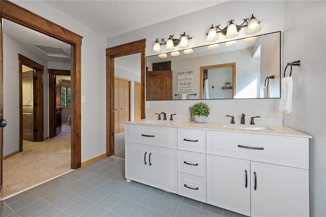 full bath featuring double vanity, baseboards, and a sink