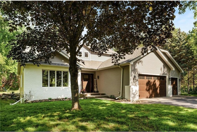 view of front facade with a garage, driveway, brick siding, and a front lawn