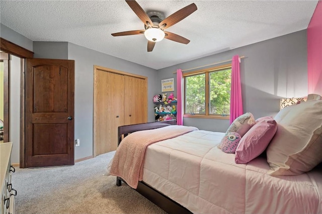 carpeted bedroom featuring a closet, baseboards, a textured ceiling, and ceiling fan